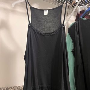 Racer back tank top with ruffles along middle and designs on scoop neck line